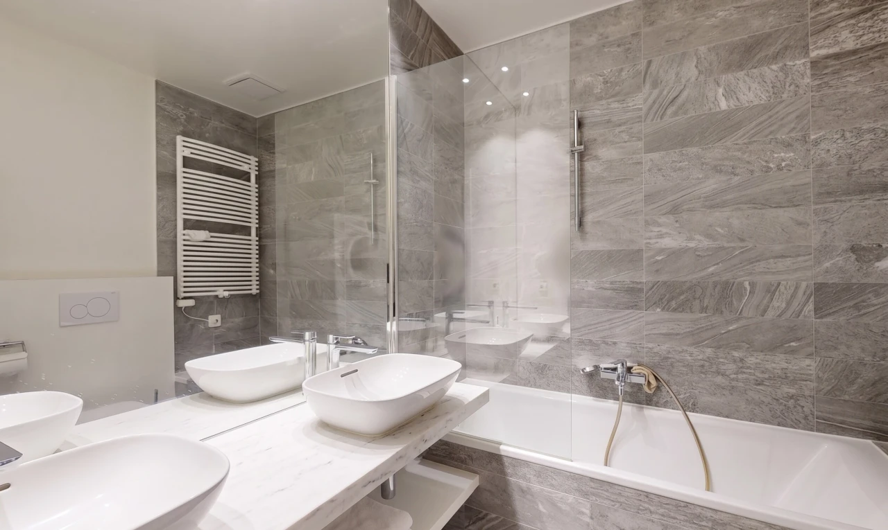 salle de bains avec radiateur, salle de bain complète, double vasque, évier, et inside property