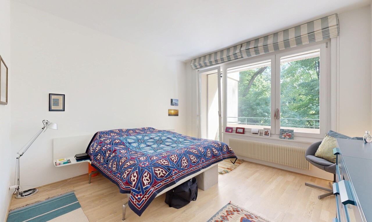 chambre avec light floor, sol en finition bois, wood finish floor, radiateur, et lumière naturelle