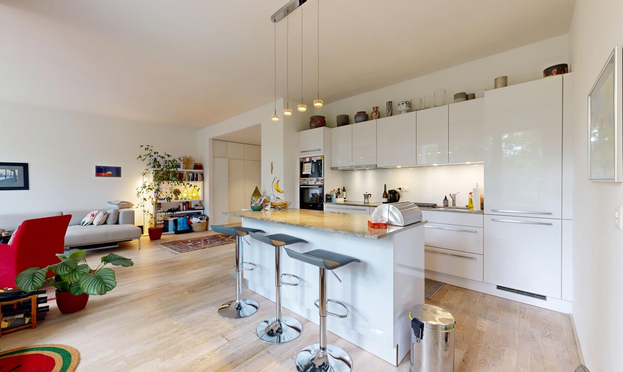 cuisine avec inside property, light countertops, îlot de cuisine, kitchen island, et armoires blanches