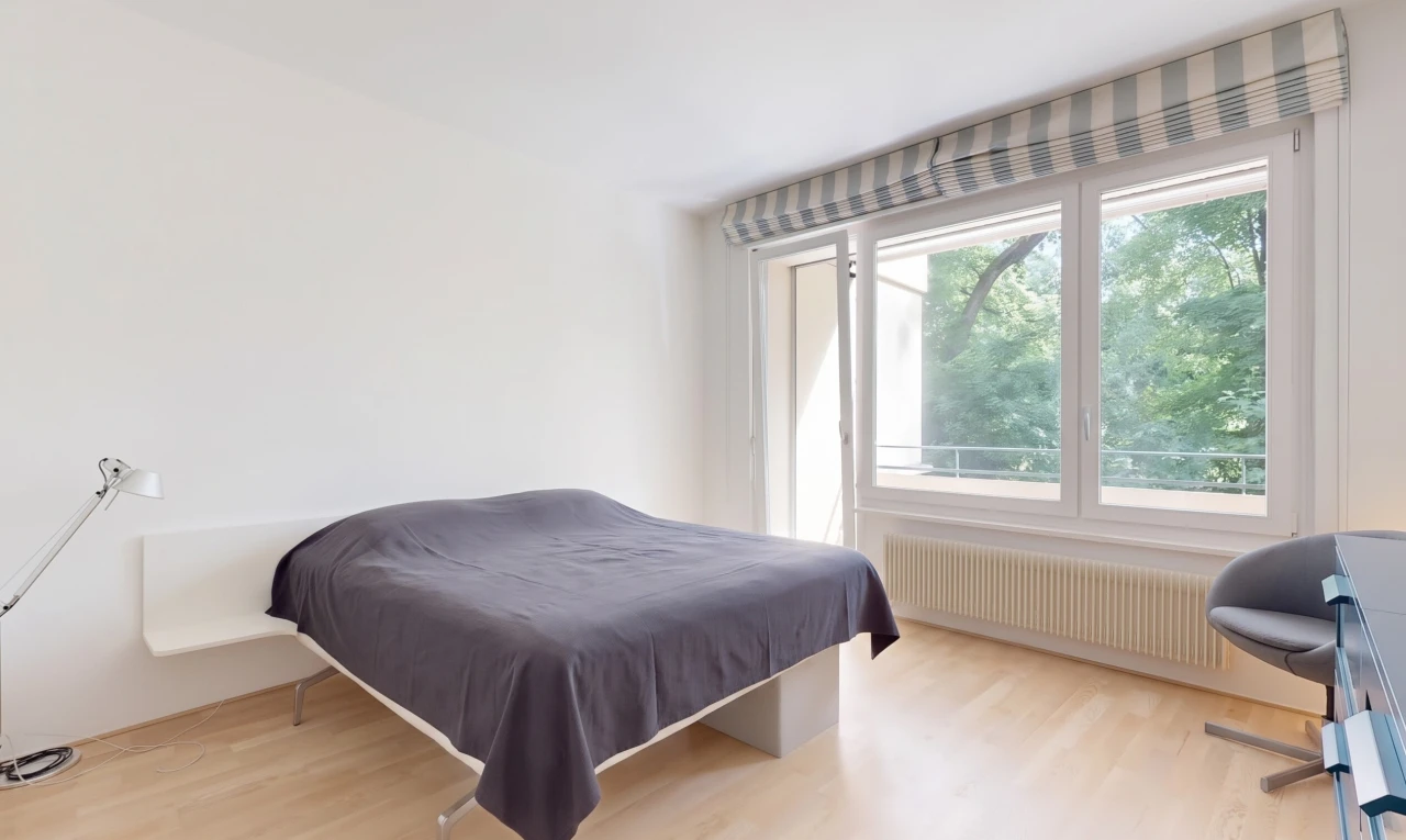 chambre avec radiateur, wood finish floor, sol en finition bois, drywall, et cloison sèche