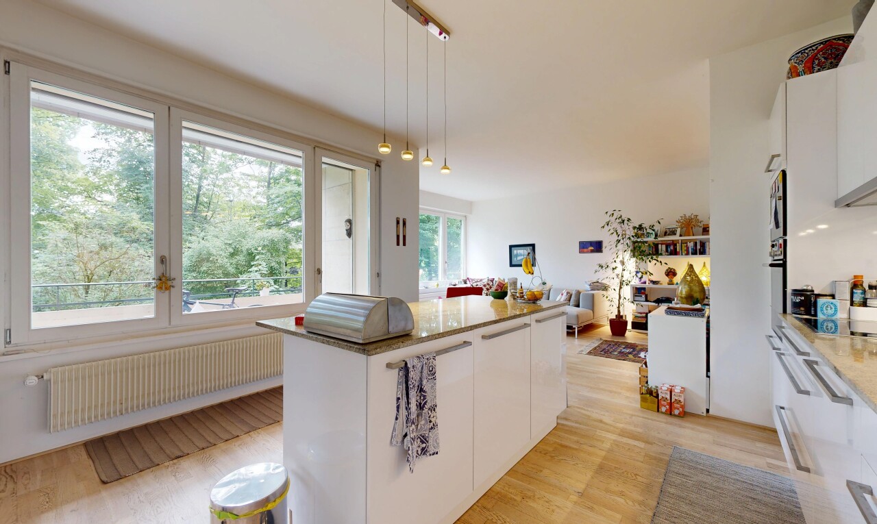 cuisine avec armoires blanches, white cabinets, sol en finition bois, wood finish floor, et îlot de cuisine