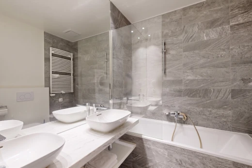 salle de bains avec radiateur, salle de bain complète, double vasque, évier, et inside property