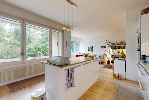 kitchen with white cabinets, light wood finished floors, a kitchen island, open floor plan, and radiator