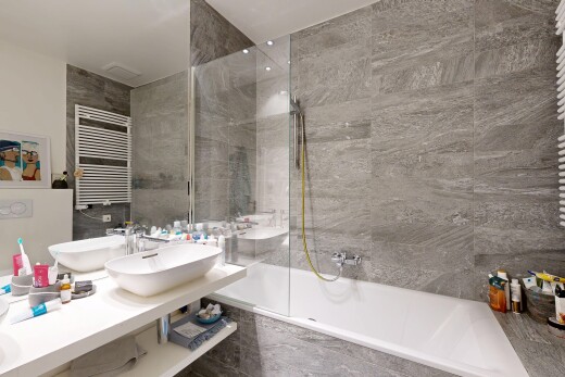 salle de bains avec chauffe-serviettes, radiateur, douche-bain combinés, salle de bain complète, et évier