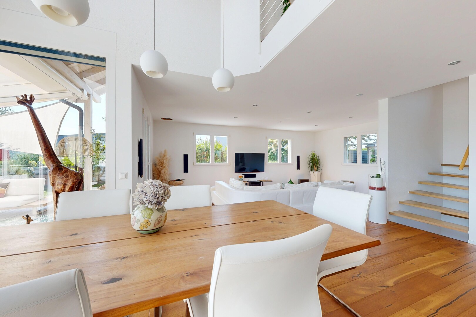 salle à manger avec escaliers, éclairage suspendu, lumière naturelle, drywall, et cloison sèche