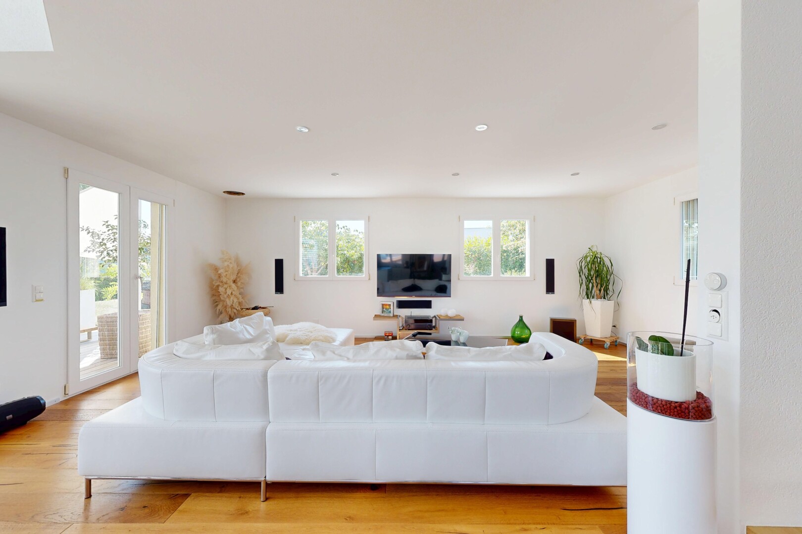 salon avec wood finish floor, sol en finition bois, lumière naturelle, éclairage encastré, et télévision