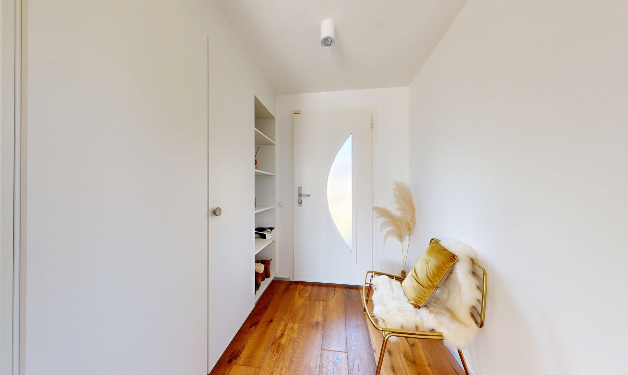 salon avec étagères intégrées, wood finish floor, sol en finition bois, drywall, et cloison sèche