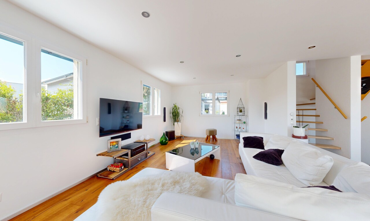 salon avec escaliers, lumière naturelle, télévision, wood finish floor, et drywall