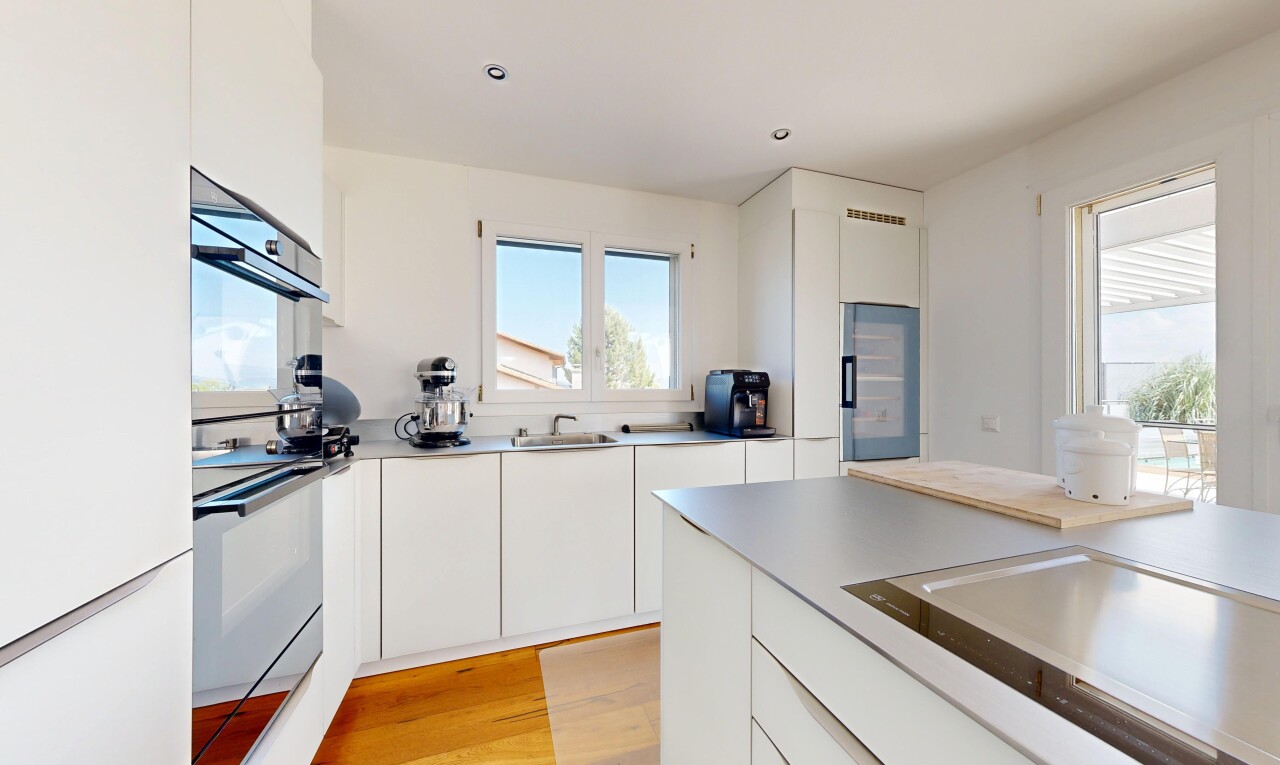 cuisine avec light floor, flat panel cabinets, armoires à panneau plat, wood finish floor, et sol en finition bois
