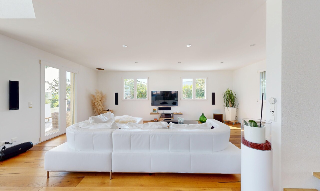 salon avec wood finish floor, sol en finition bois, lumière naturelle, éclairage encastré, et télévision