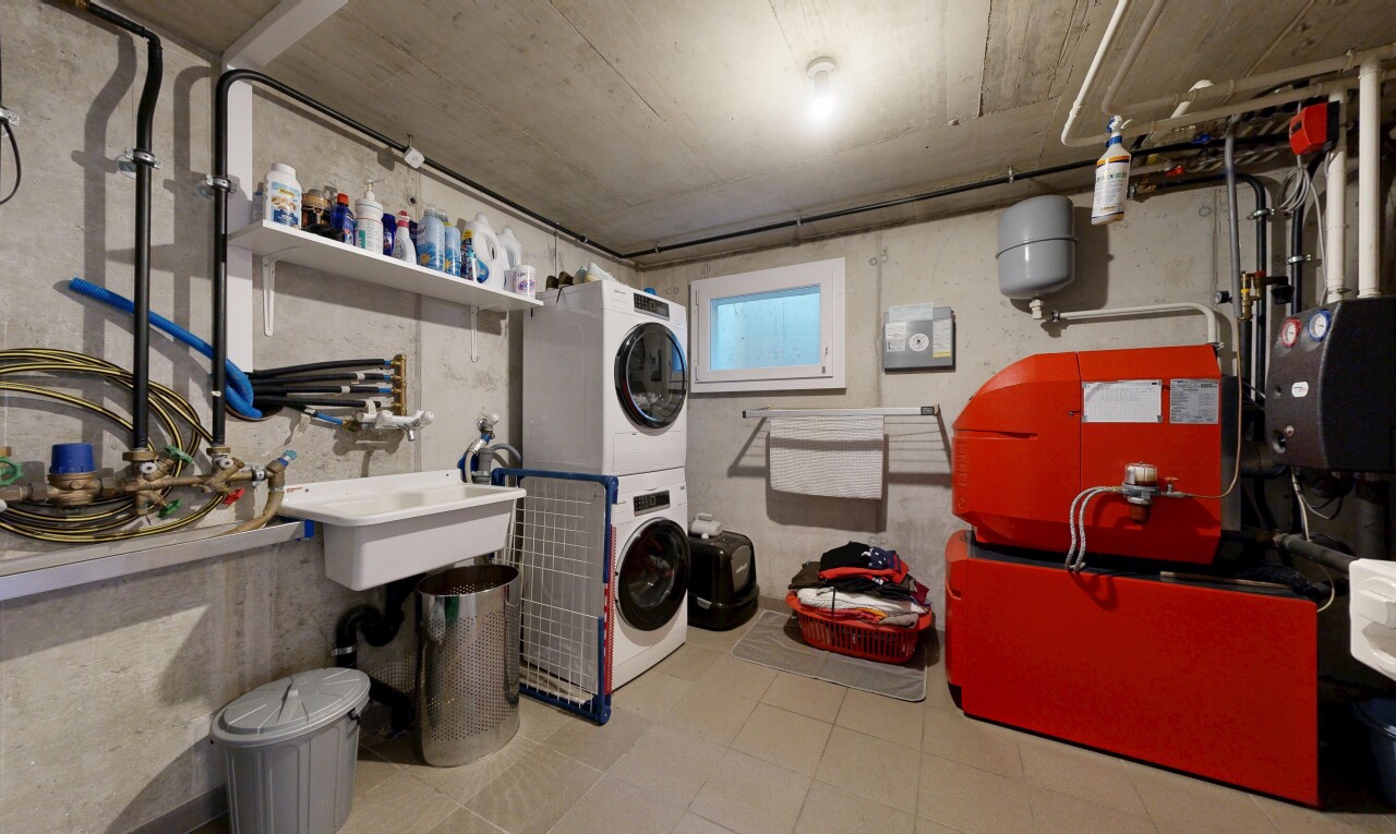 buanderie avec concrete wall, mur en béton, lave-linge et sèche-linge superposés, concrete ceiling, et plafond en béton