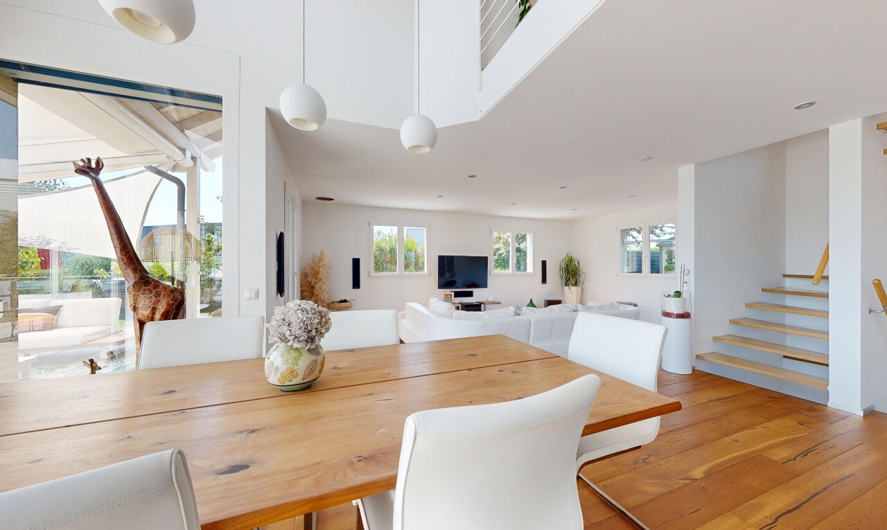 salle à manger avec escaliers, éclairage suspendu, lumière naturelle, drywall, et cloison sèche