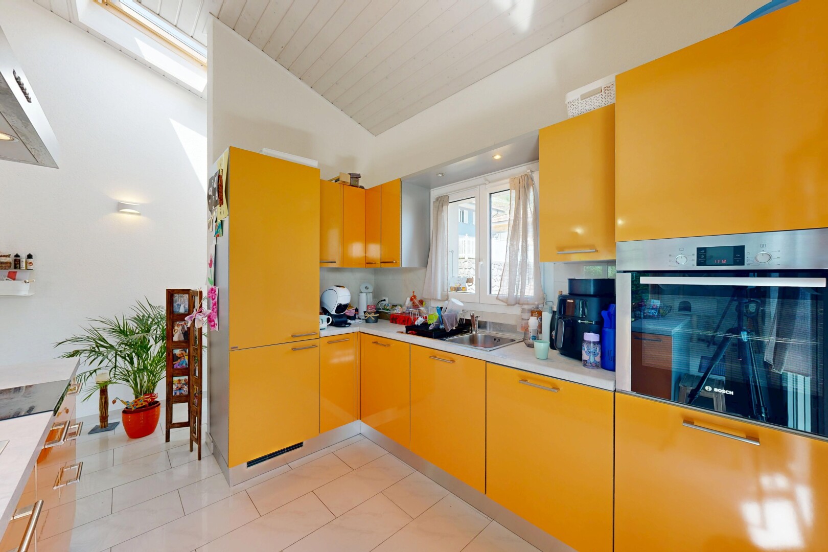 cuisine avec four, inside property, plans de travail, light countertops, et lumière naturelle
