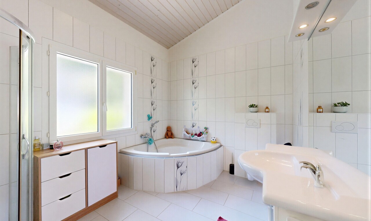 salle de bains avec mur en carrelage, tile wall, salle de bain complète, light floor, et bain