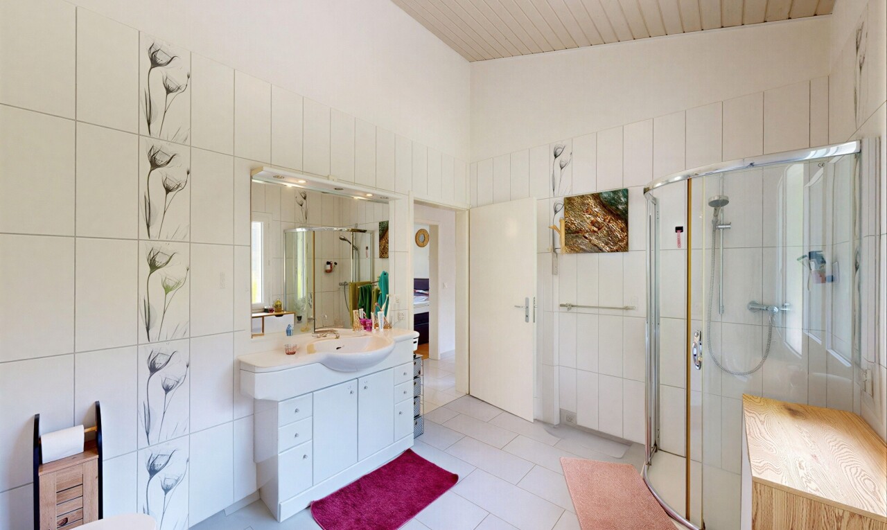 salle de bains avec mur en carrelage, tile wall, lavabo (ou coiffeuse selon le contexte), douche, et salle de bain complète
