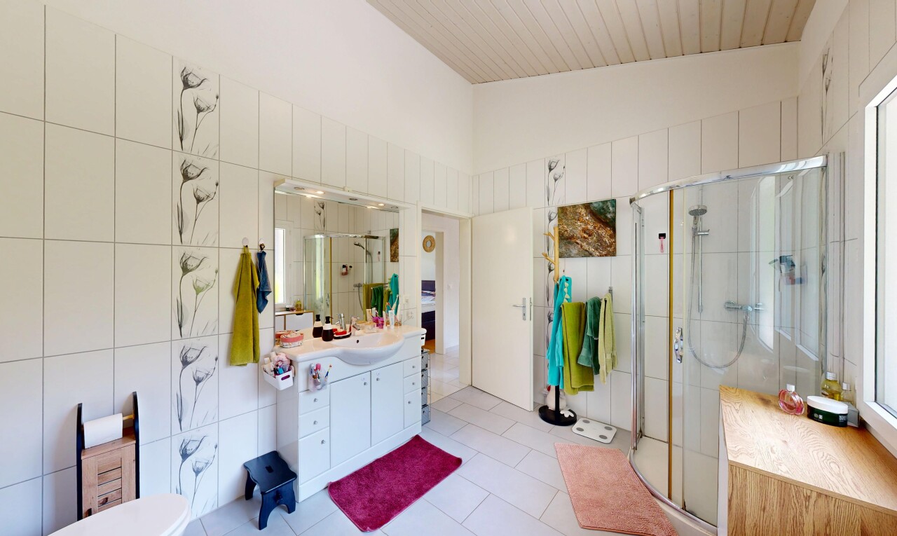 salle de bains avec mur en carrelage, tile wall, lavabo (ou coiffeuse selon le contexte), douche, et salle de bain complète