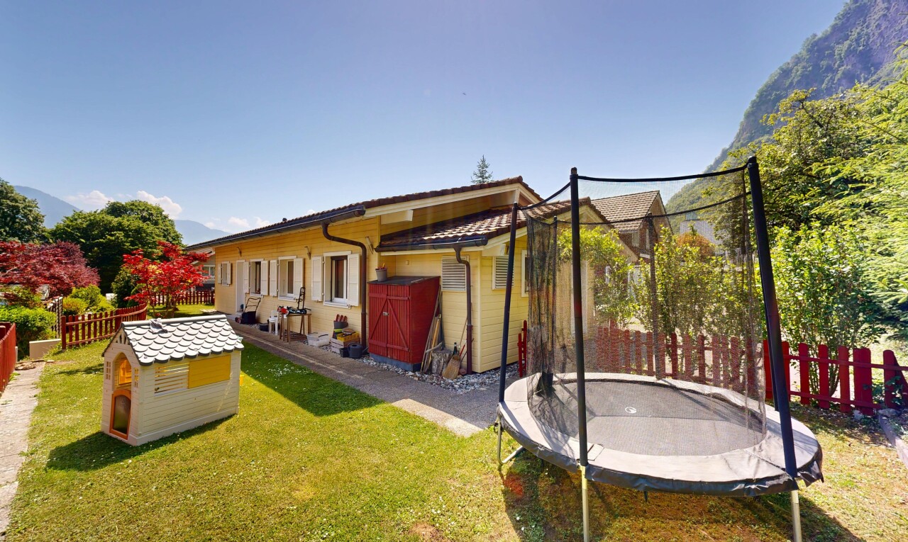 façade avec clôture, trampoline, property visible, pelouse, et day time