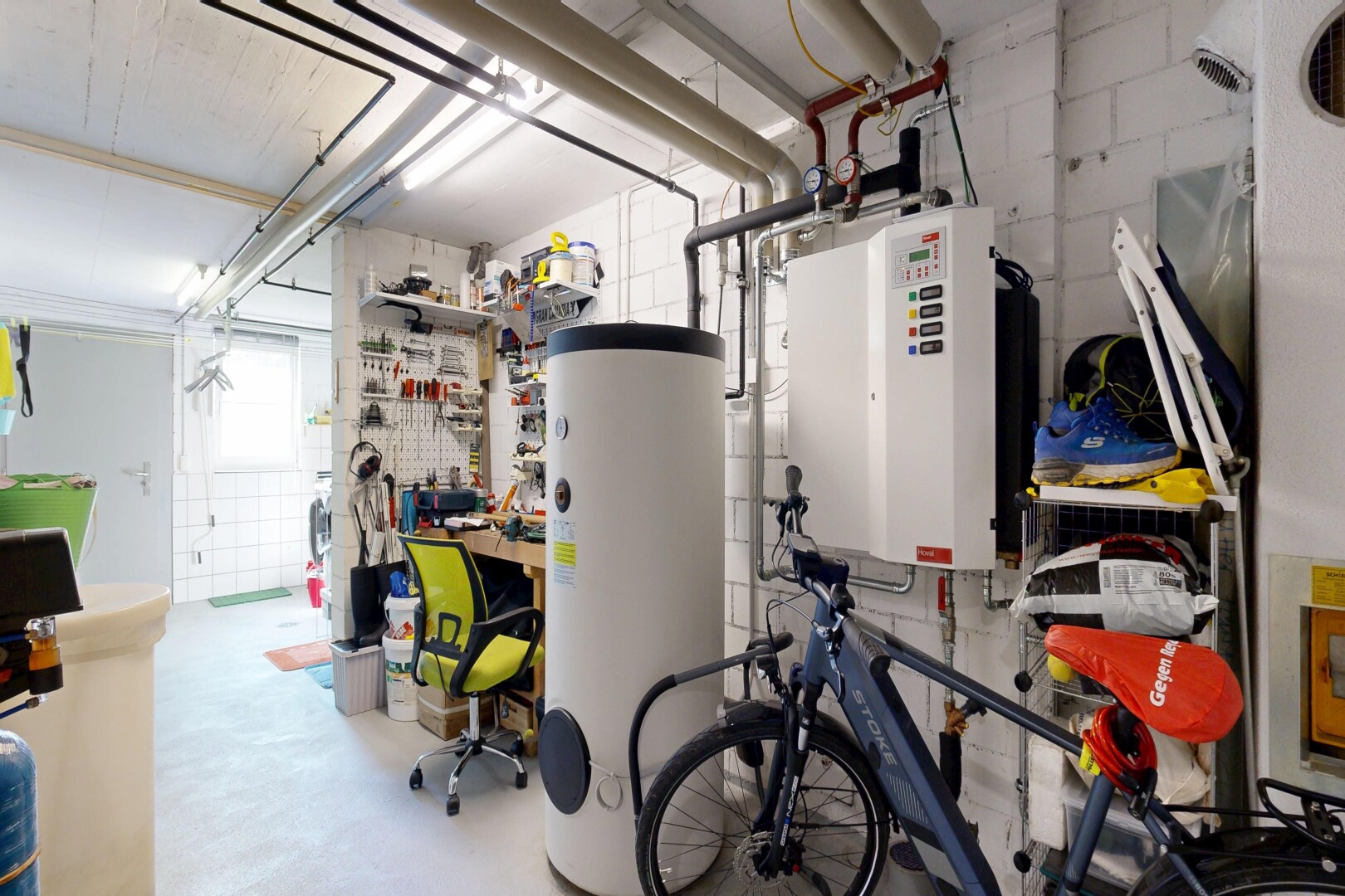 gym avec chauffe-eau, inside property, sol en béton, et concrete floor