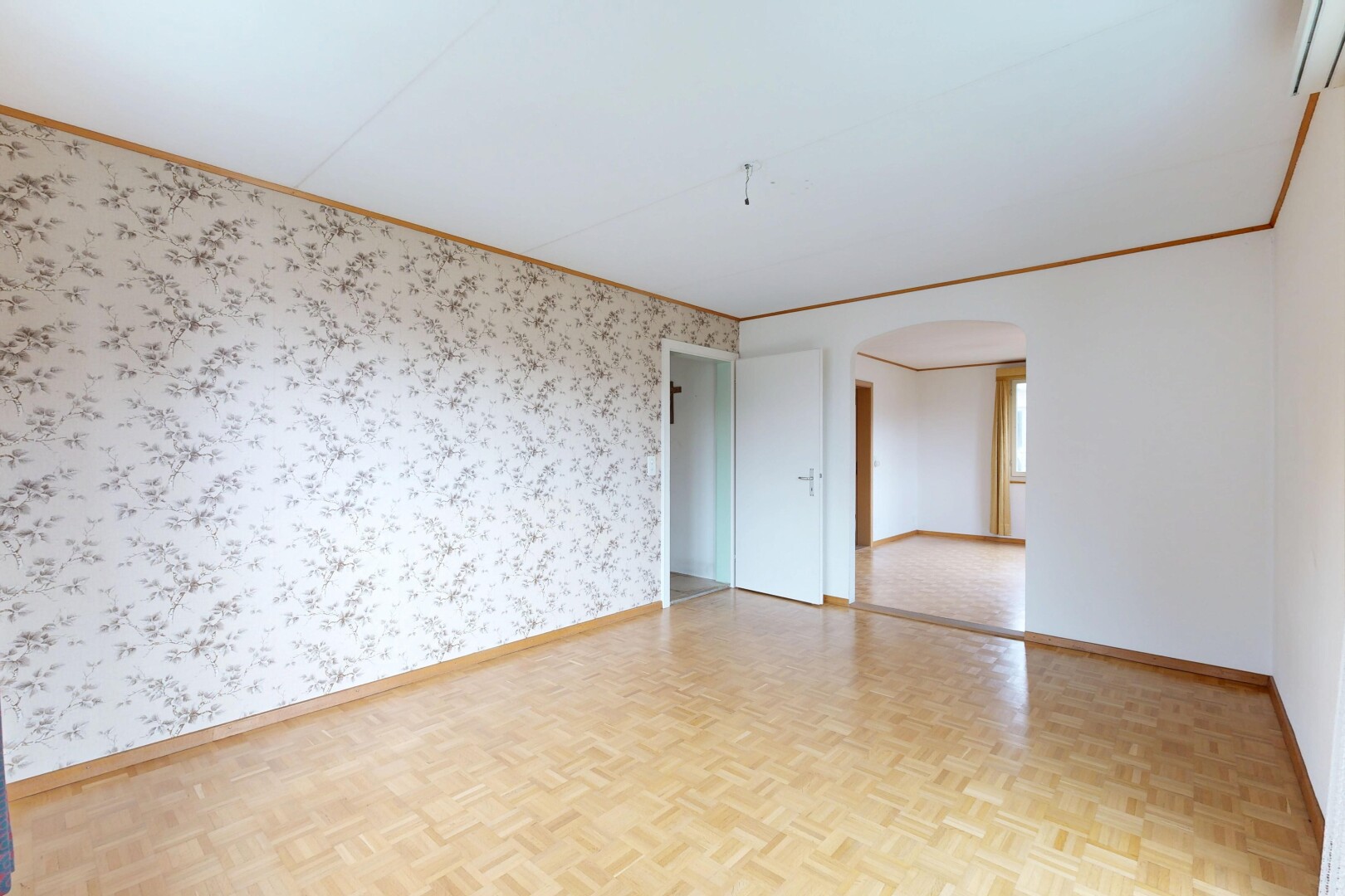pièce vide avec passages en arc, parquet floor, mur en papier peint, wallpaper wall, et inside property