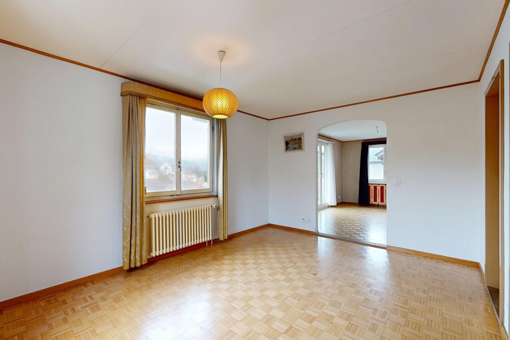 pièce vide avec passages en arc, parquet floor, plinthes murales, baseboards wall, et lumière naturelle