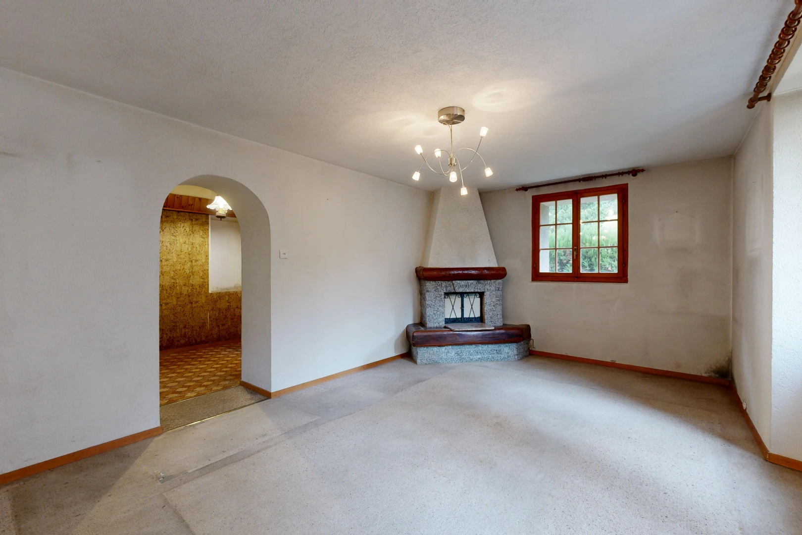salon avec passages en arc, cheminée, inside property, moquette, et carpet