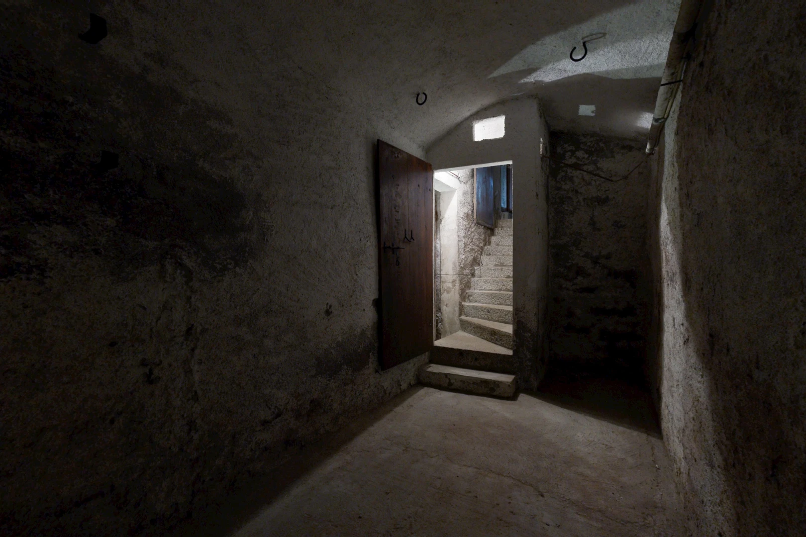 couloir avec escaliers, concrete floor, sol en béton, et sous-sol