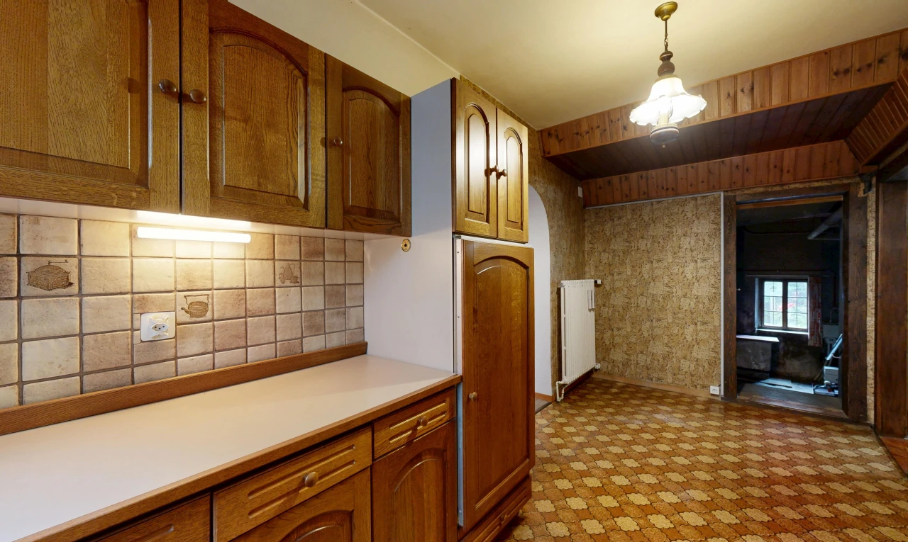 cuisine avec armoires en arc, arched cabinets, plans de travail, light countertops, et armoires marron moyen