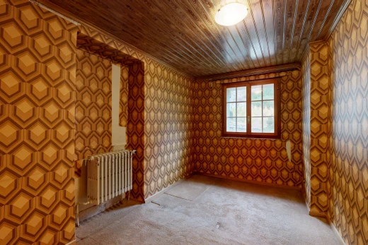 pièce vide avec radiateur, mur en papier peint, wallpaper wall, plafond en bois, et wood ceiling