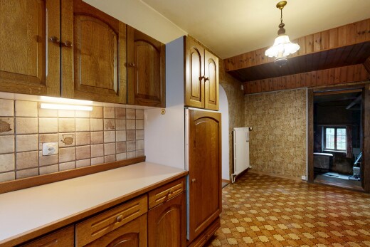 cuisine avec armoires en arc, arched cabinets, plans de travail, light countertops, et armoires marron moyen