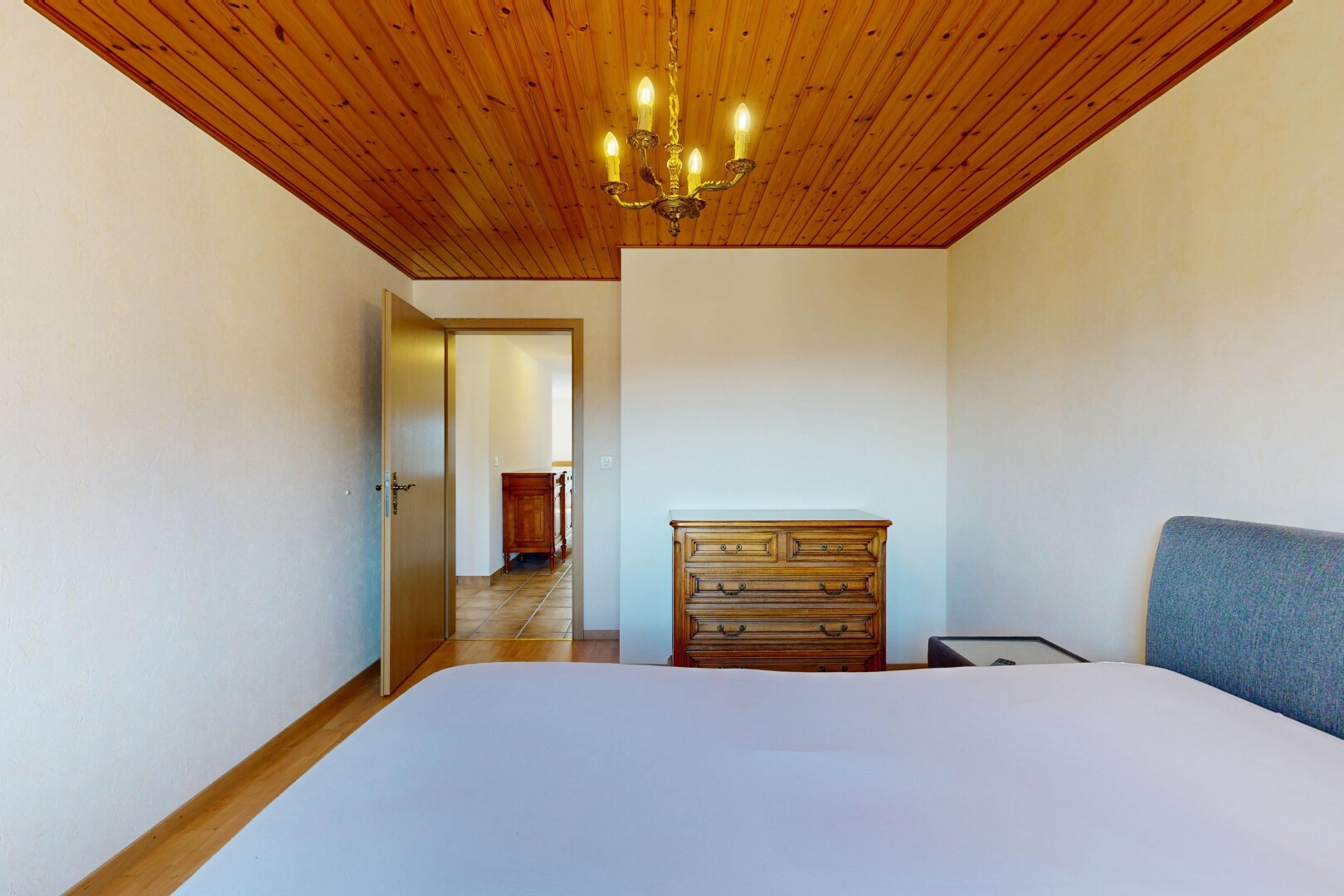 chambre avec inside property, cloison sèche, drywall, lustre remarquable, et sol en finition bois