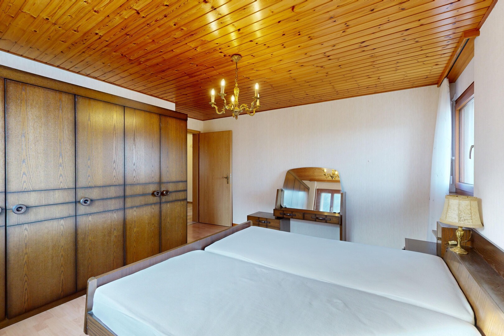 chambre avec inside property, lustre remarquable, plafond en bois, wood ceiling, et lumière naturelle