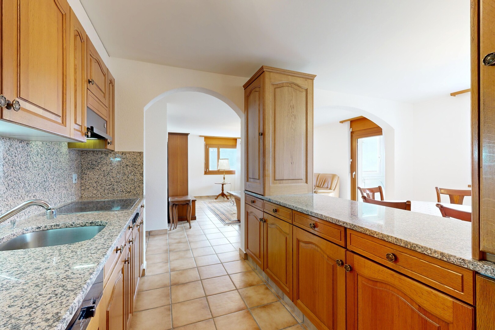 cuisine avec arched cabinets, armoires en arc, stone countertops, plans de travail en pierre, et light countertops