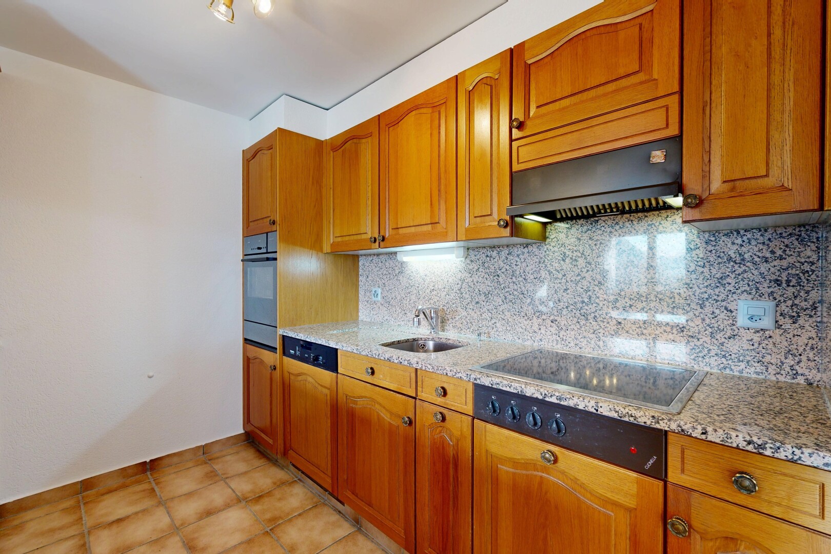 cuisine avec arched cabinets, armoires en arc, light countertops, light floor, et inside property