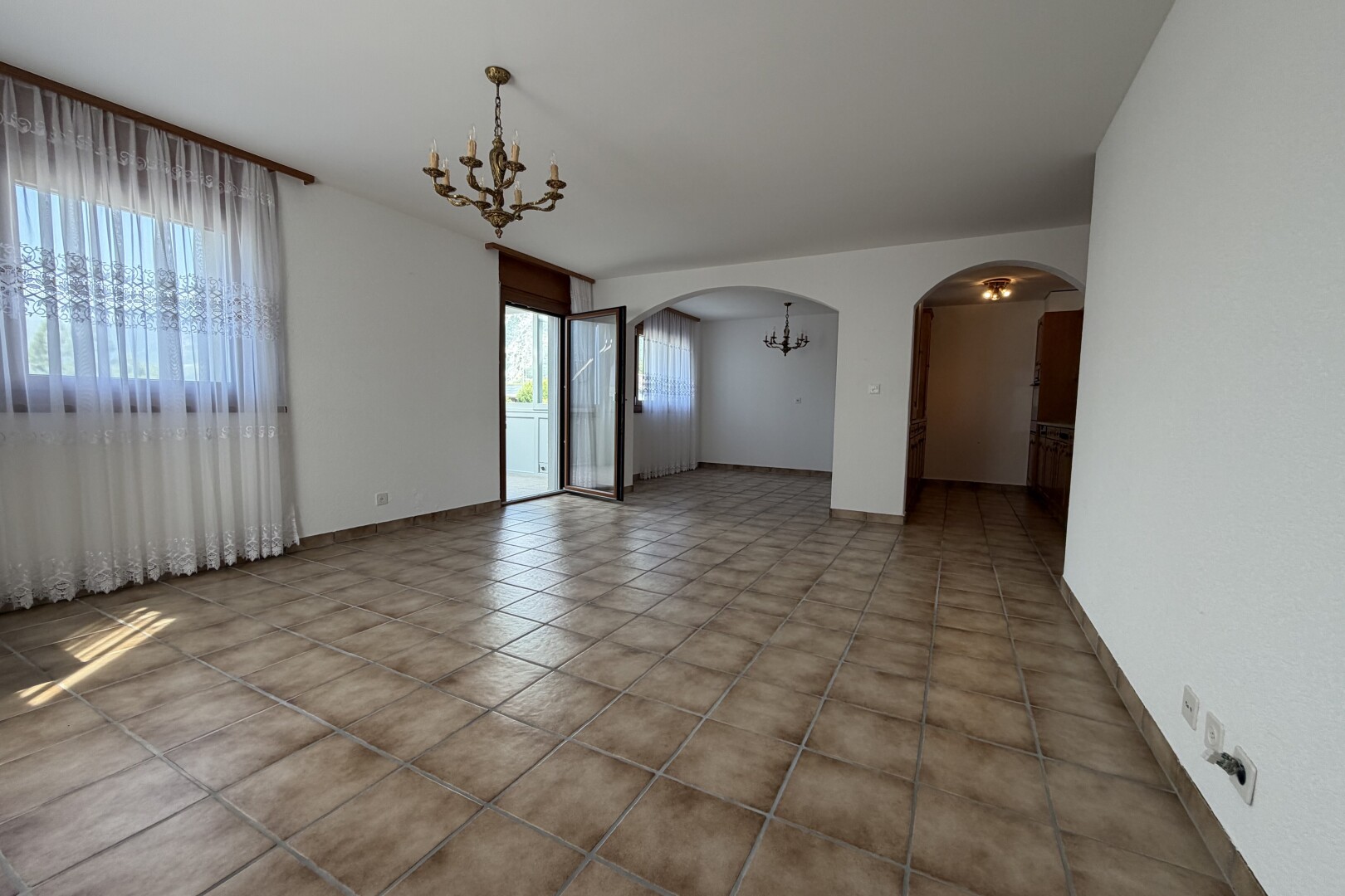 pièce vide avec cloison sèche, drywall, passages en arc, inside property, et plinthes murales