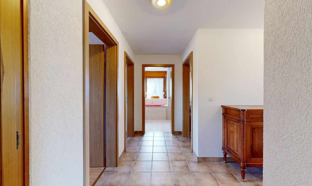 couloir avec inside property, sol en carrelage, tile floor, mur texturé, et textured wall