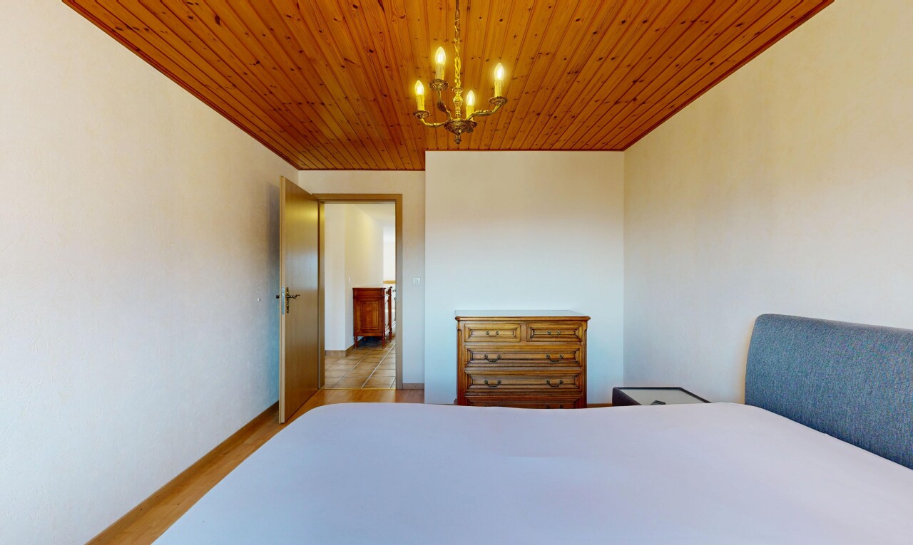 chambre avec inside property, cloison sèche, drywall, lustre remarquable, et sol en finition bois