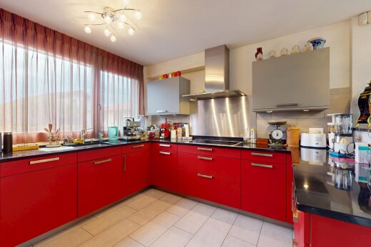 cuisine avec armoires rouges, hotte, natural light, lumière naturelle, et inside property