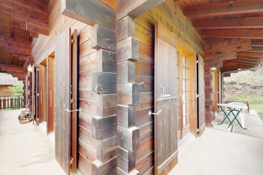 hall featuring wooden walls, lofted ceiling with beams, and wooden ceiling