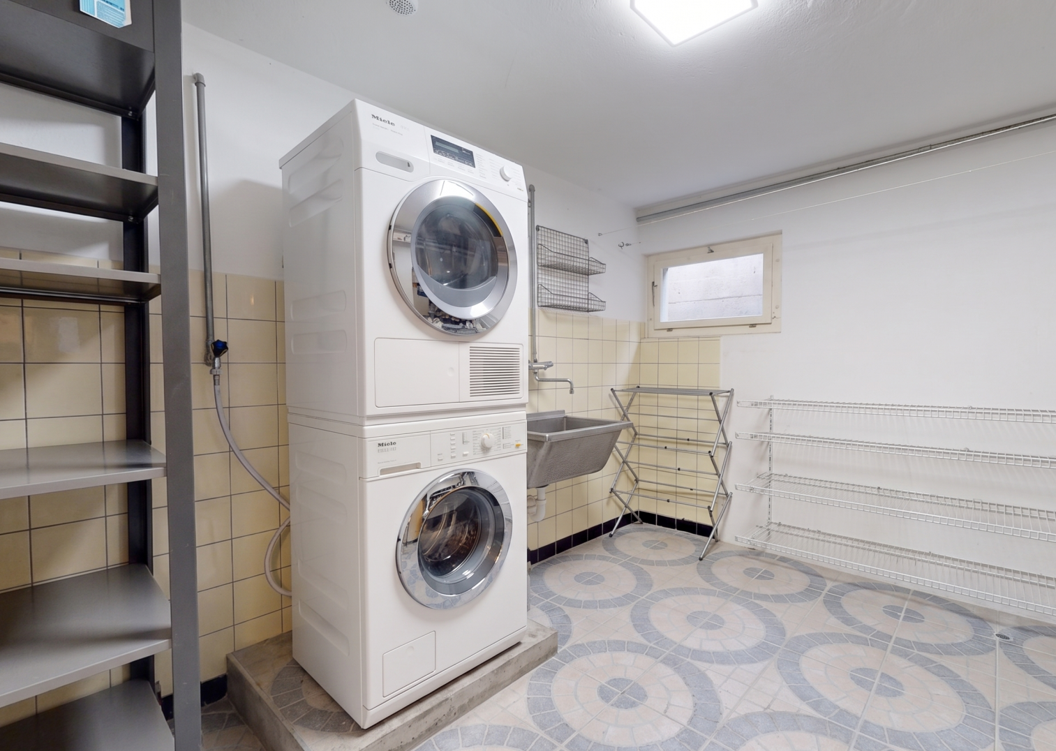 buanderie avec lave-linge et sèche-linge superposés, light floor, évier, buanderie, et inside property
