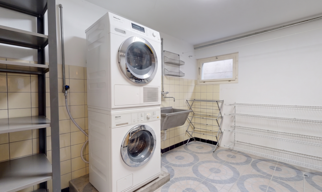 buanderie avec lave-linge et sèche-linge superposés, light floor, évier, buanderie, et inside property