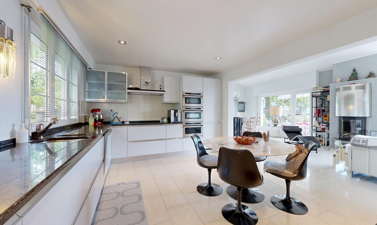 cuisine avec armoires avec insert en verre, glass insert cabinets, inside property, hotte, et armoires blanches