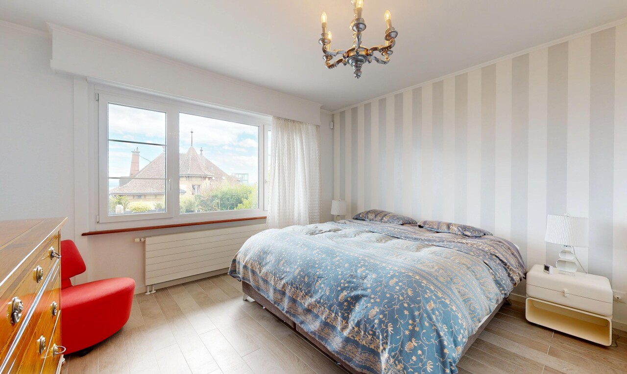 chambre avec wallpaper wall, mur en papier peint, wood finish floor, sol en finition bois, et lustre remarquable
