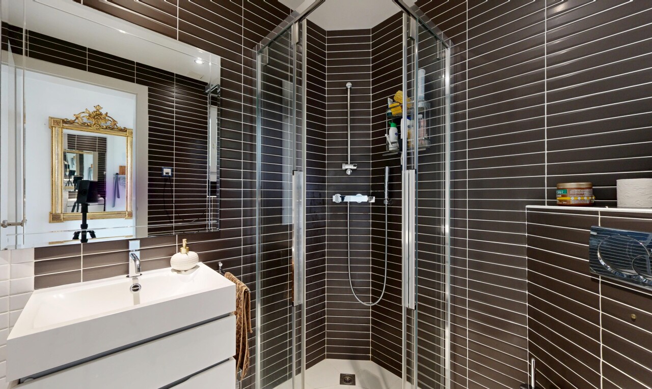 salle de bains avec miroir, lavabo (ou coiffeuse selon le contexte), douche, salle de bain complète, et inside property