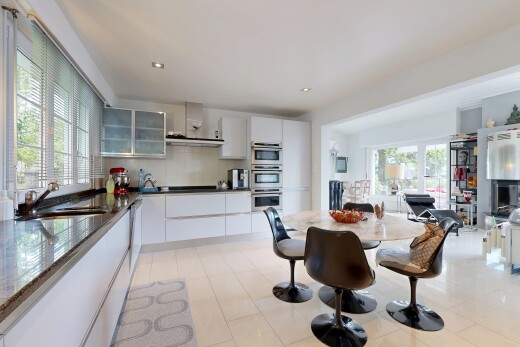 cuisine avec armoires avec insert en verre, glass insert cabinets, inside property, hotte, et armoires blanches