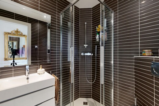 salle de bains avec miroir, lavabo (ou coiffeuse selon le contexte), douche, salle de bain complète, et inside property