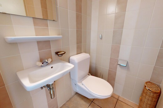 salle de bains avec mur en carrelage, tile wall, toilette, miroir, et inside property