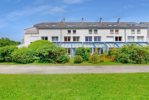façade avec day time, pelouse, property visible, bardage en stuc, et toit à joints debout