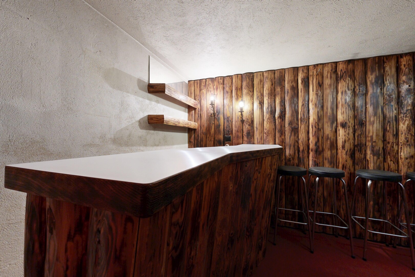 staircase featuring a bar, built in features, wooden walls, and a textured ceiling