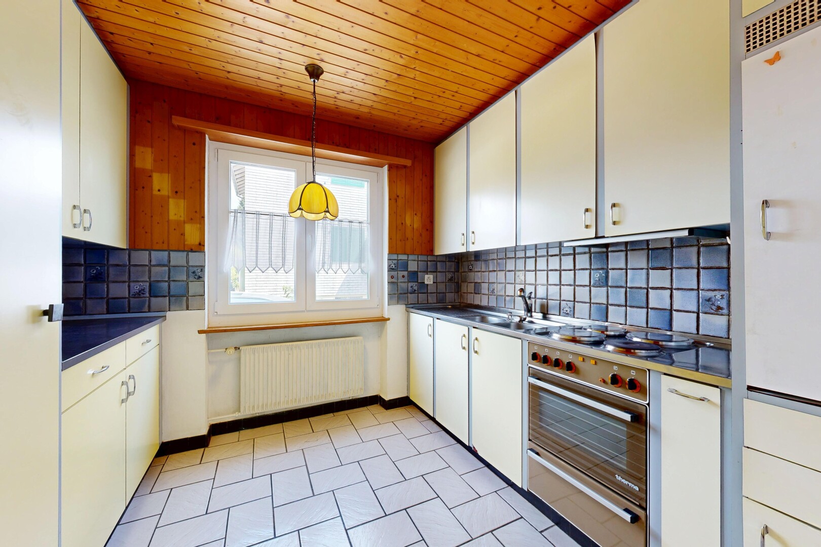kitchen with decorative backsplash, dark countertops, radiator, wood ceiling, and white cabinets