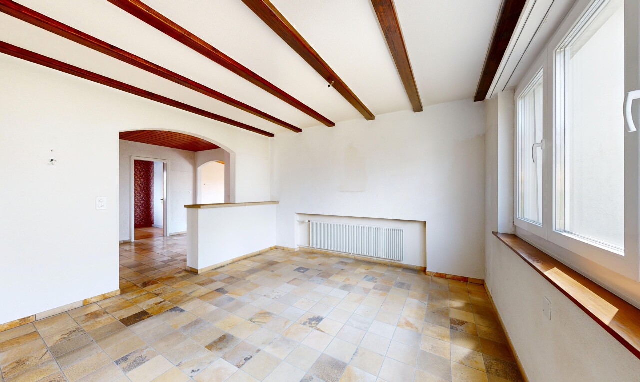 spare room featuring beamed ceiling, radiator heating unit, and arched walkways
